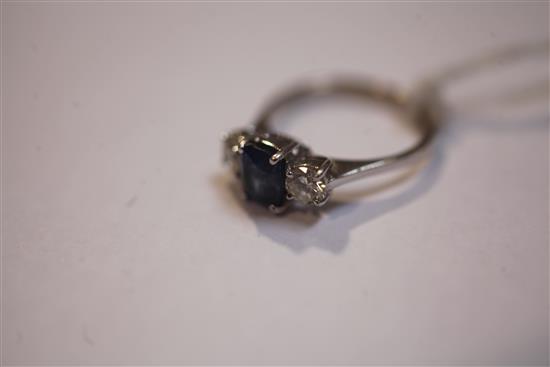 A modern 18ct white gold and three stone diamond and sapphire ring, size J.